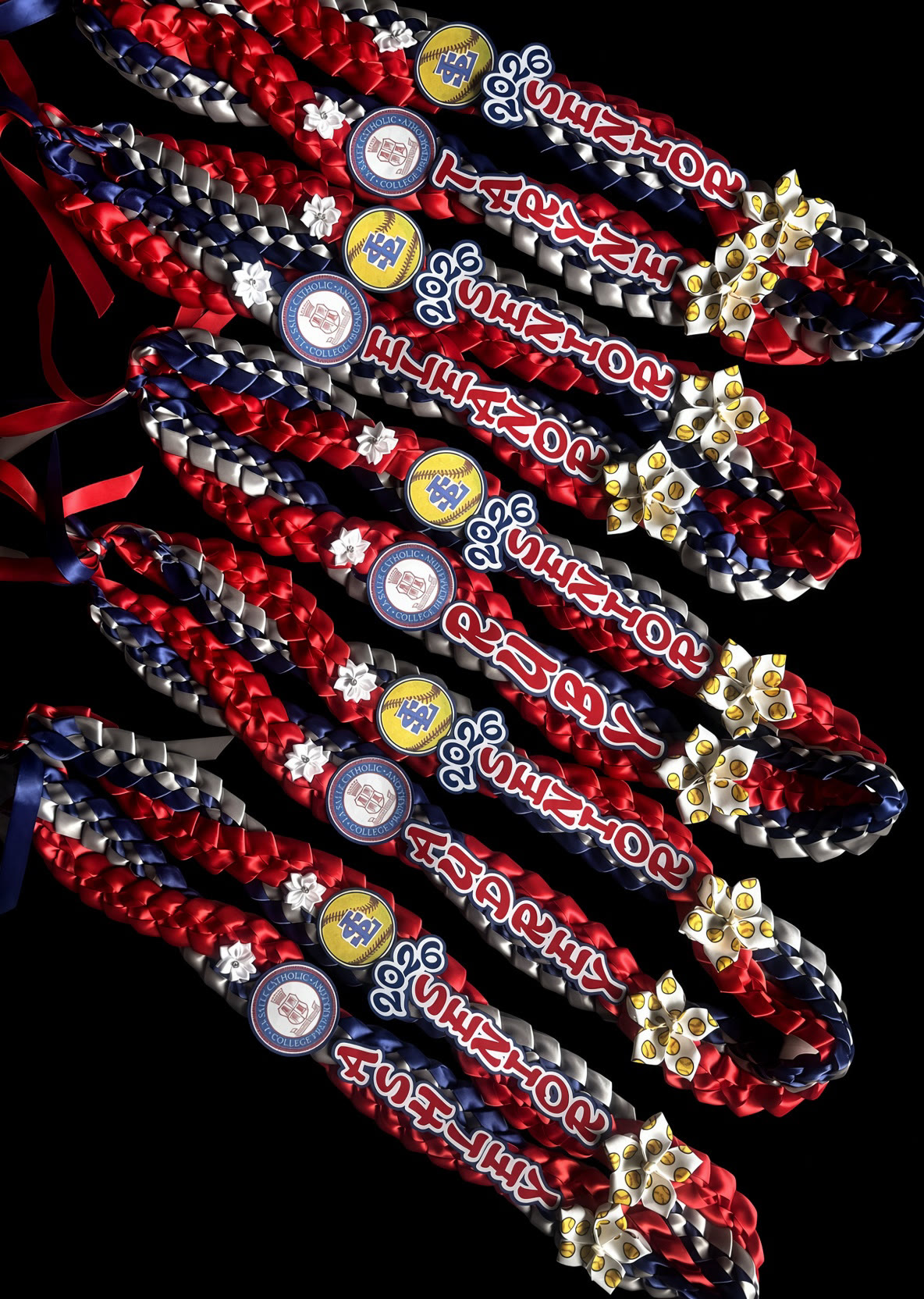Multiple team ribbon leis with names, years, and sports logos